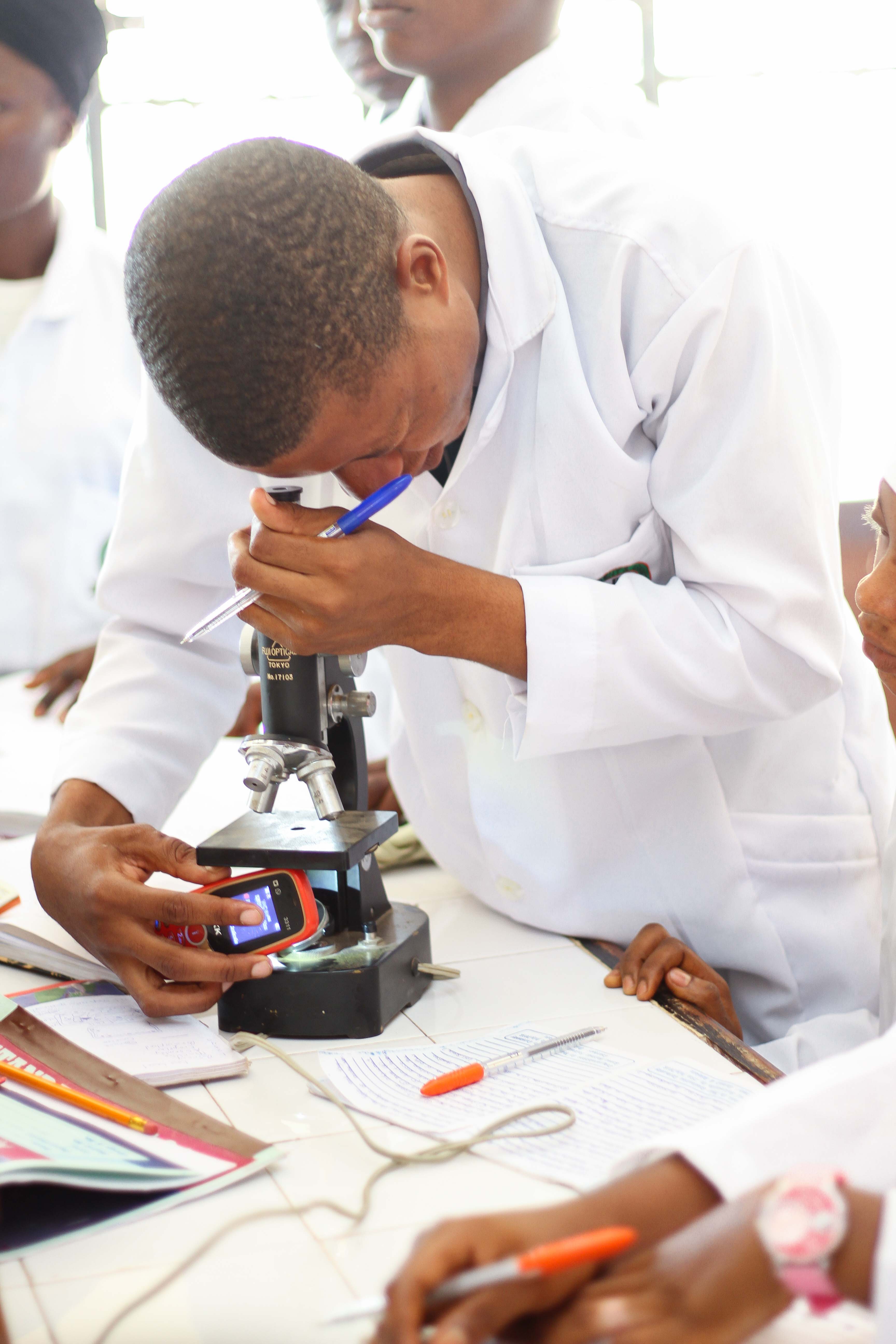 Student practising how to use a microscope
